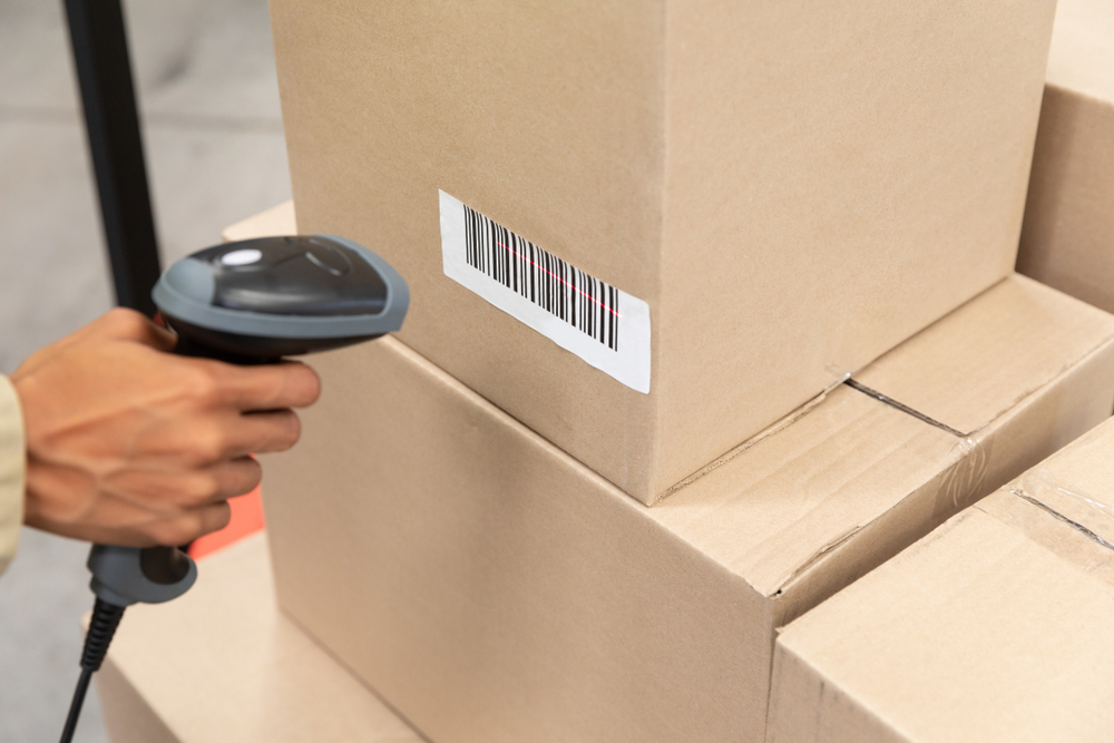 Close-up of female worker scanning package with barcode scanner in warehouse. This is a freight transportation and distribution warehouse. Industrial and industrial workers concept_id1477534346