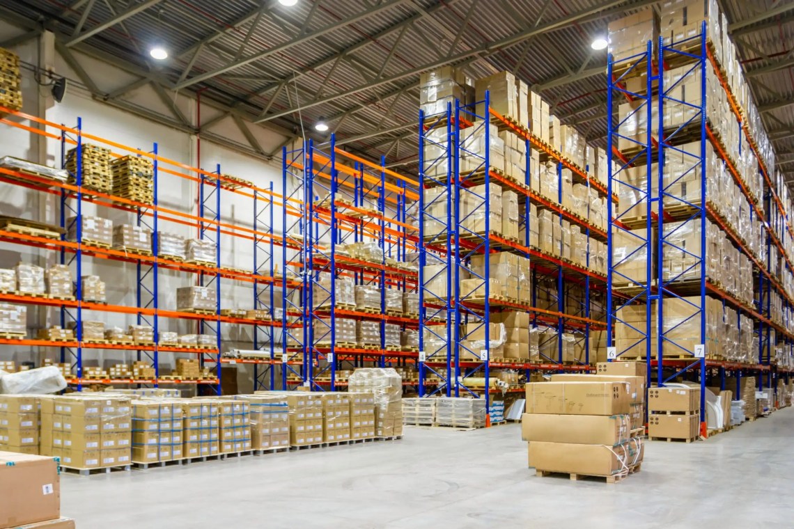 The interior of a warehouse with racks reaching to the ceiling.