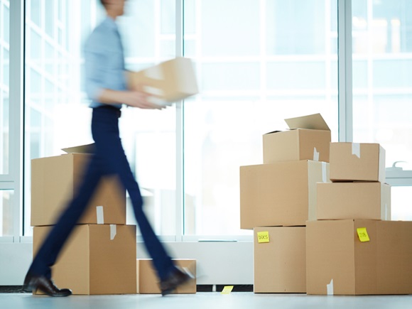 Blurry motion of businessman carrying boxes from one office to another during relocation_id1038208828