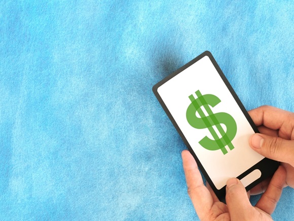 Hand holding a mobile phone with dollar money currency sign. Make money online and electronic banking concept_id2435985463