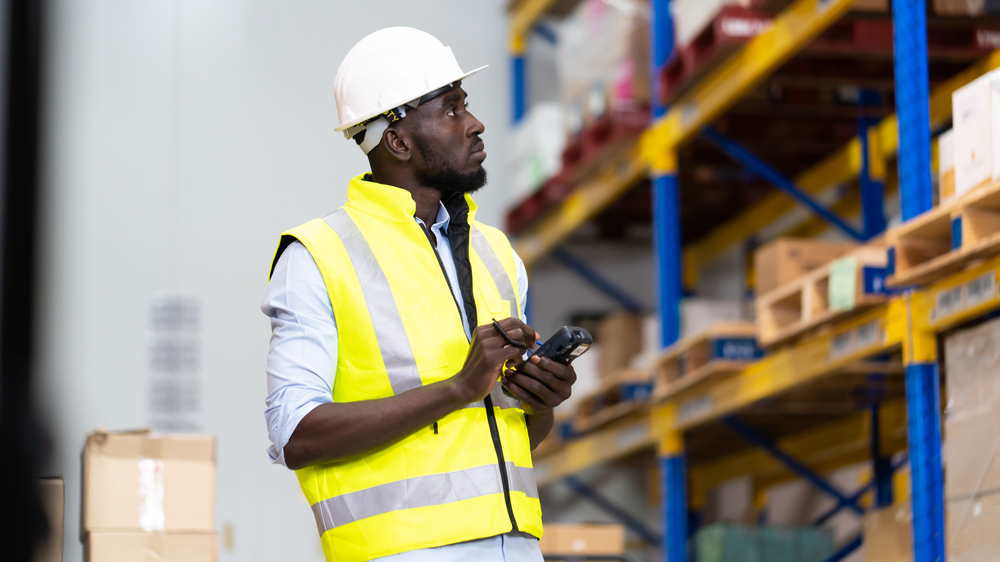 Man in a warehouse tracing products.