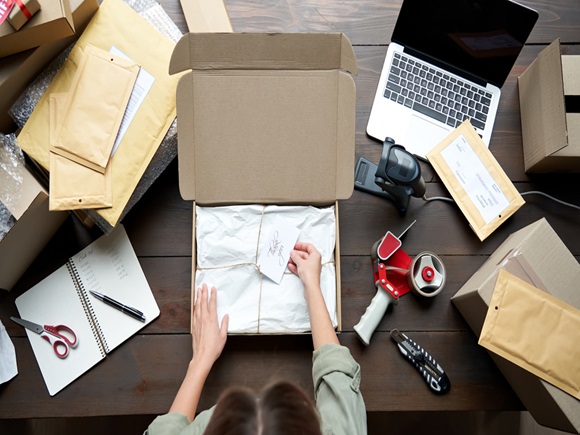 Top above closeup view of female online store small business owner entrepreneur packing package post shipping box preparing delivery parcel on table. Ecommerce dropshipping shipment service concept_id1831476526