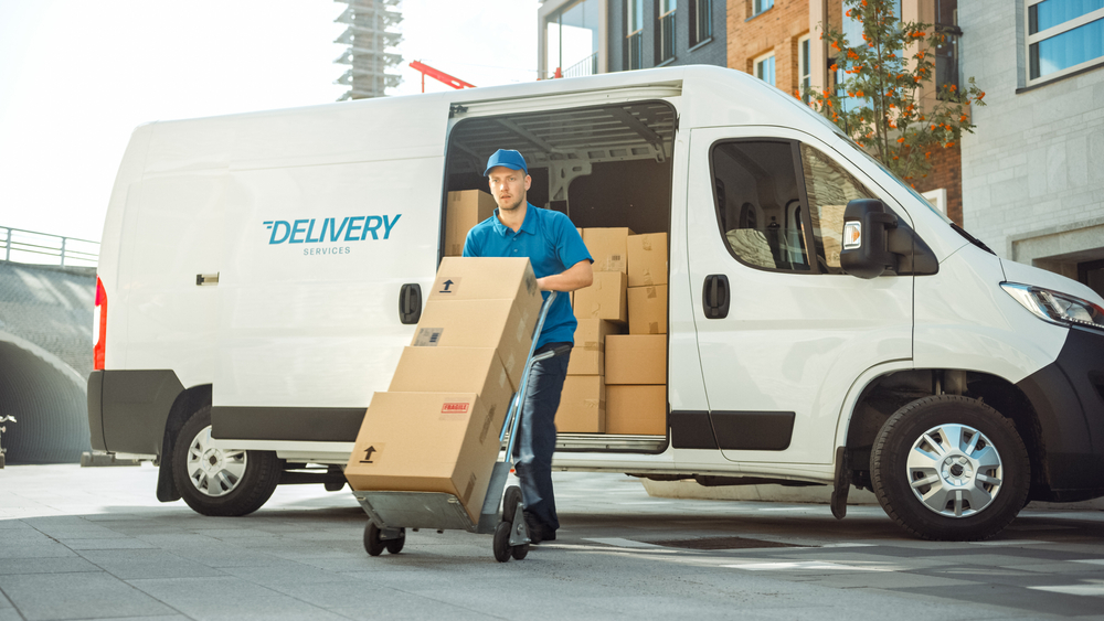Man delivering packages after they were unloaded from a shipping van.