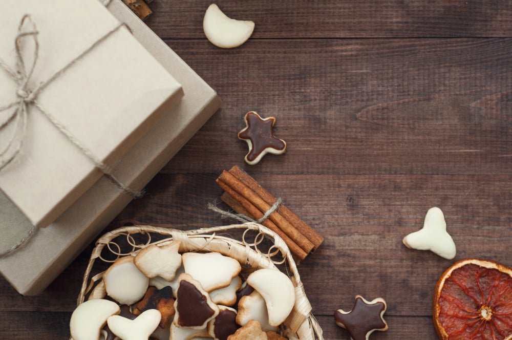 Top view of Christmas background. Christmas presents,cookies and dry oranges on a brown wooden table._id1143273374
