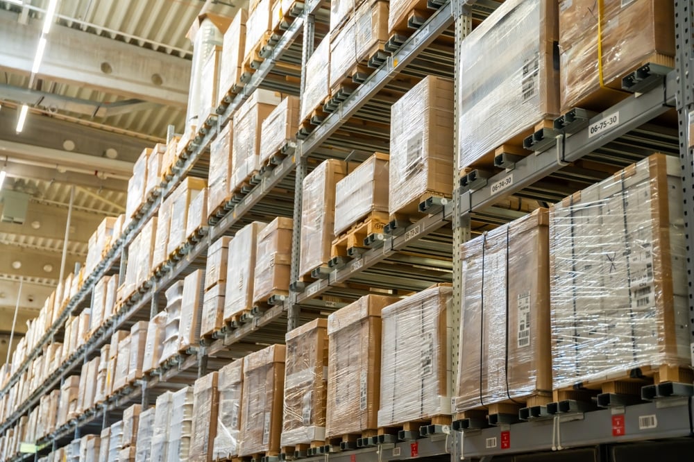 Long shelves with many cardboard boxes with product in warehouse, representing stockpile inventory