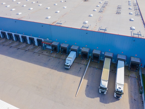 Aerial Shot of Industrial Loading Area where Many Trucks Are Unloading Merchandise_1824932777