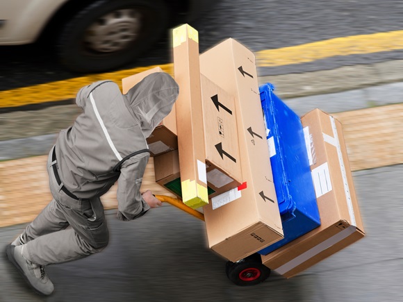 Delivery courier worker with packages boxes with boxcar for delivering in city_id2442925409