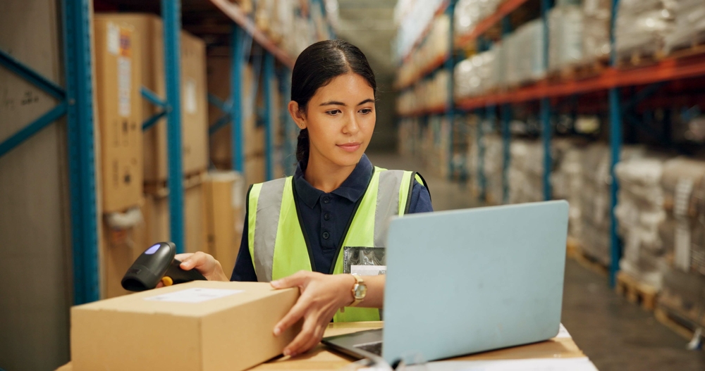 Woman in warehouse tracking info.
