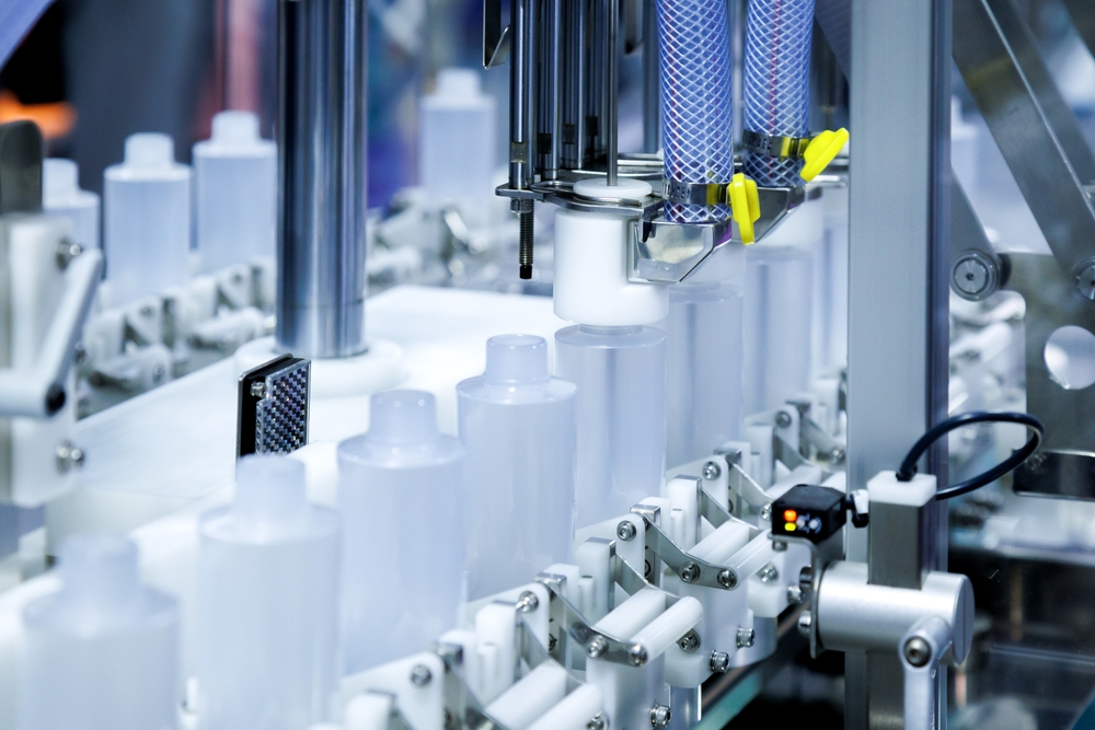 Production line with white plastic bottles ready to be filled in a supplier plant.