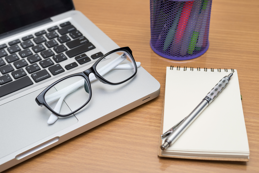 Blank business laptop, pen, note and glasses on wooden table_245699686