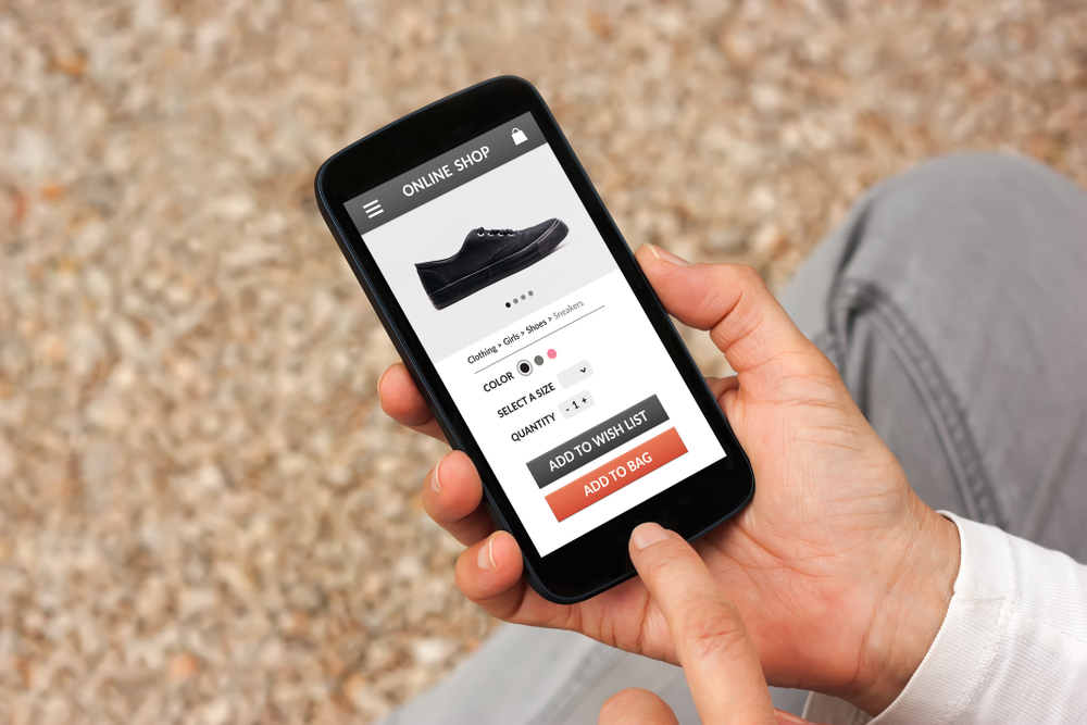 Hands holding smart phone with online shop concept on screen. All screen content is designed by me_id1065671627