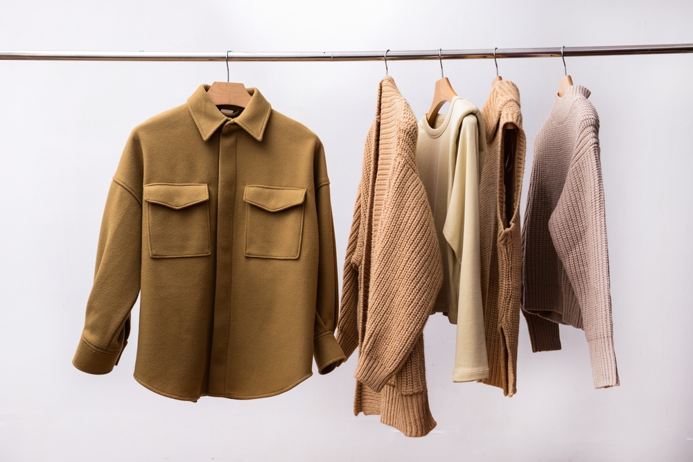 Row of five,vest sweaters,brown shirt close up on hanger_id2164747283