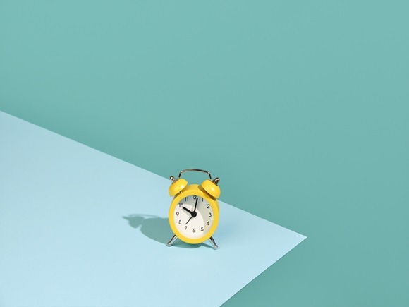 Small yellow alarm clock on a two-color background_id2070623561
