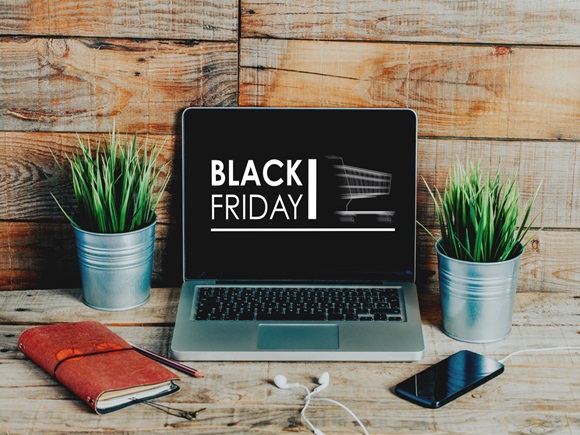 Black Friday and big sale in electronics store concept. Laptop and credit card surrounded by cardboard boxes with protective foam pads and electronic products inside. Flat lay_id747186991