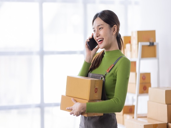 Startup happy Asian woman business owner works with a box at home, prepare parcel delivery SME supply chain, procurement, package box to deliver to customers, Online SME business entrepreneurs ideas,_id2334407243