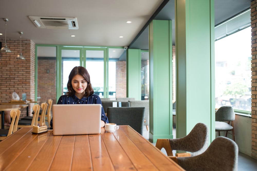 Beautiful cute asian young businesswoman in the cafe, using laptop and drinking coffee smiling_id500276974