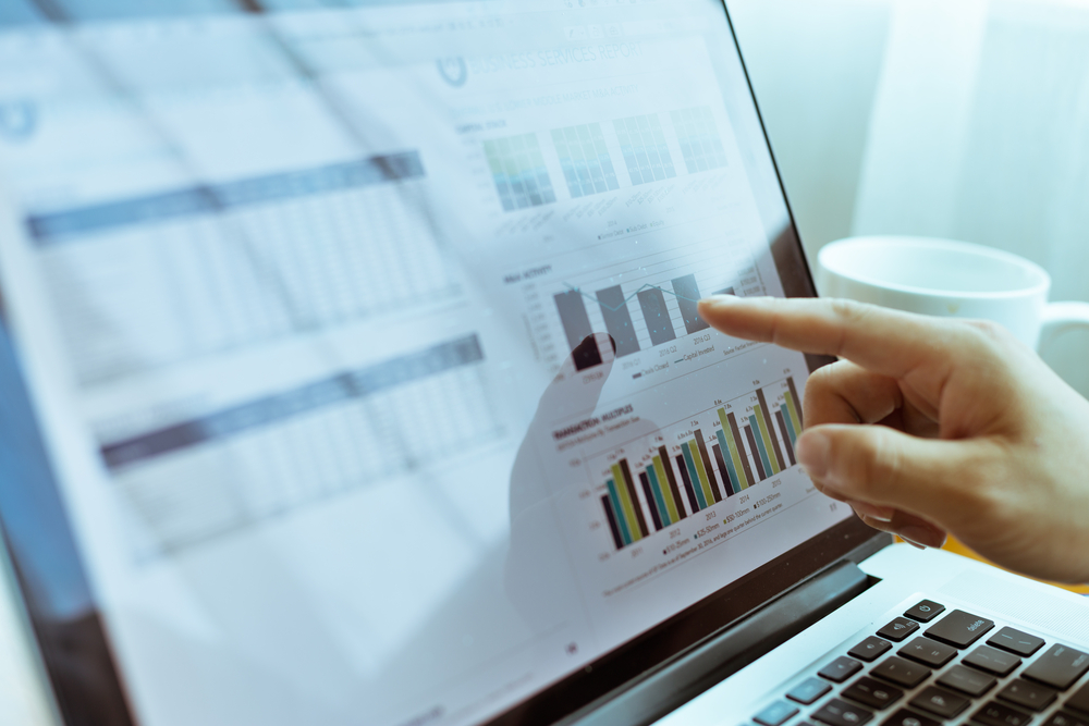 Young man checks business report by laptop_id703085233