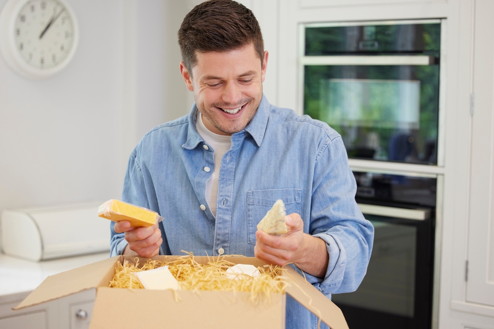 A man unboxing his subscription service received in the mail.