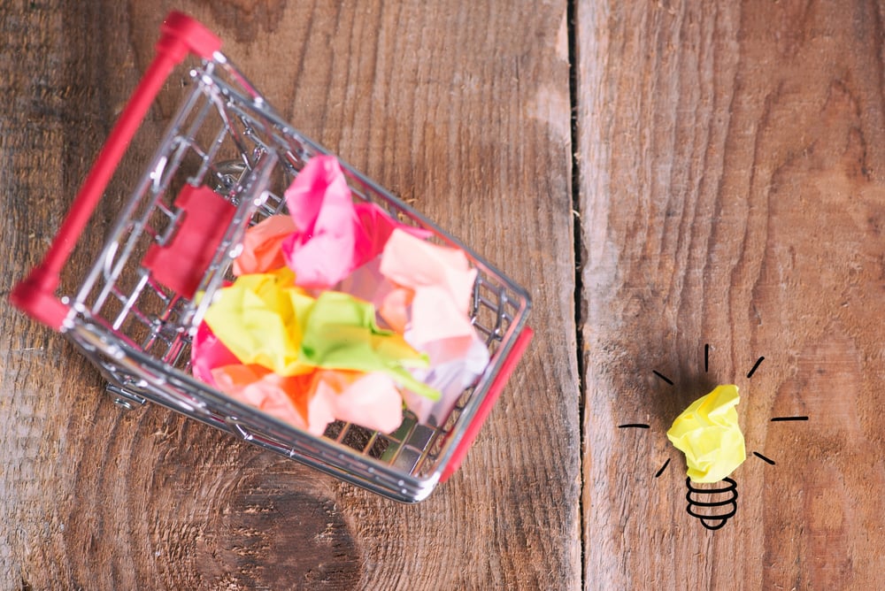 Shopping cart and small paper balls. Thinking about new idea. Ideas about e-commerce, e-commerce or commerce_id703452499