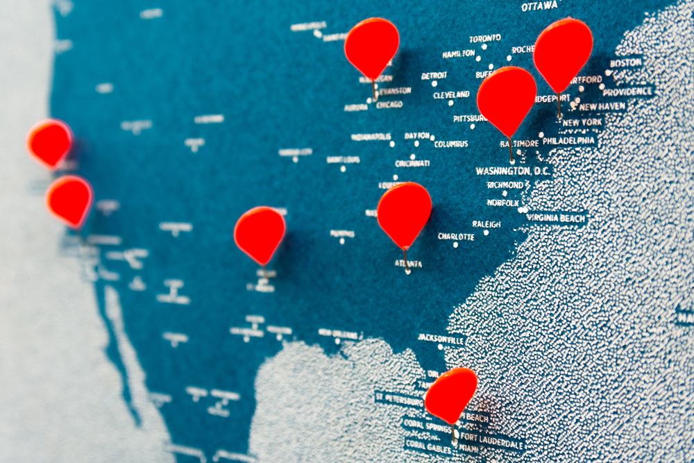 Image of map of North America with red pins in multiple locations