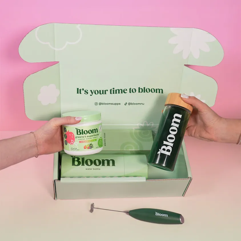 A green, custom-branded box from Bloom Nutrition with Bloom Nutrition products inside