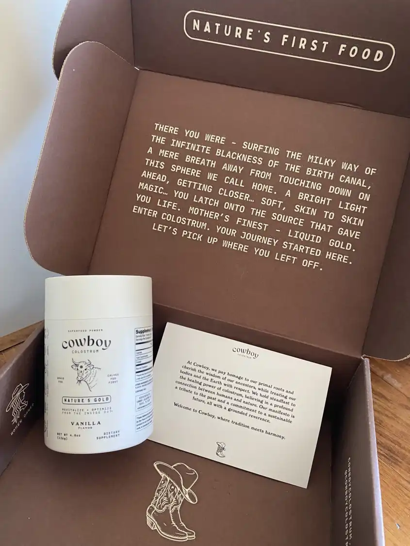 A custom box from Cowboy Colostrum with a container of their product and a custom marketing insert inside