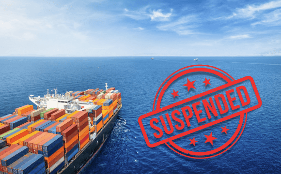 Freight ship in the ocean with a sticker with the word "suspended" on it, denoting the Section 321 suspension.