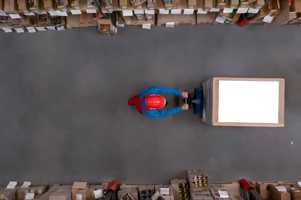 Man working with pallet truck at warehouse, top view. Logistics center _id2149107907