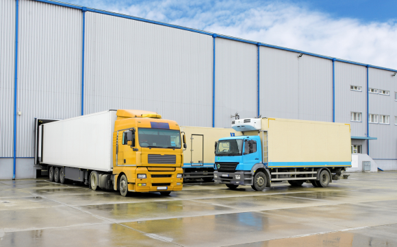 multiple carrier trucks picking up parcels at a warehouse